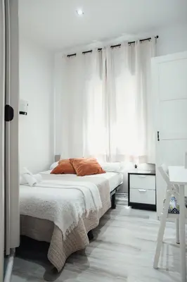 a bedroom with two beds with white curtains at Hostal Ruta de Francia in Barcelona