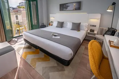 a hotel room with a bed and a balcony at SERHS Carlit Boutique Hotel in Barcelona