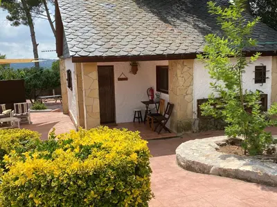 a small house with a patio with yellow flowers at Pinedes Verd in La Torre de Claramunt