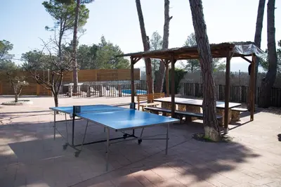 a ping pong table and a gazebo at Pinedes Verd in La Torre de Claramunt