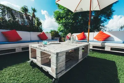 a wooden coffee table in front of a couch and an umbrella at Entre Olivos: Very Charming Villa 18 SLEEPERS in Sant Pere de Ribes