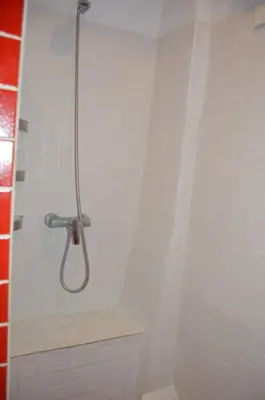 a shower with a hose in a white tiled bathroom at Entre Olivos: Very Charming Villa 18 SLEEPERS in Sant Pere de Ribes