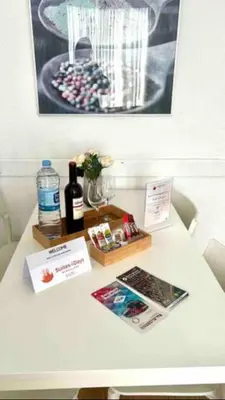 a white table with a bottle of wine and magazines at SANTS STATION PENTHOUSE in Barcelona