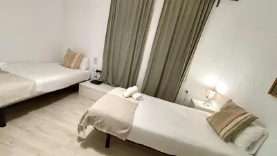 a white room with two beds and a window at Sagrada Familia - Sant Pau apartment in Barcelona