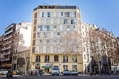 a tall building with cars parked in front of it at Sweett - Comte Urgell in Barcelona