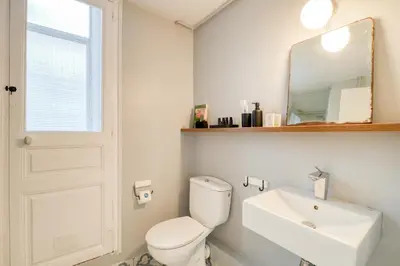 a bathroom with a toilet and a sink and a mirror at Sweett - Comte Urgell in Barcelona