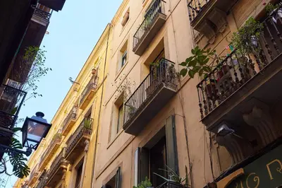 a tall yellow building with balconies and windows at Casa Cosi - Gotico in Barcelona