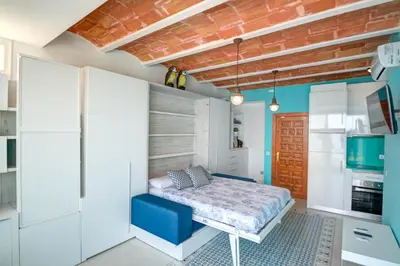 a bedroom with a bed and a kitchen at Blue sea front by Hello Homes Sitges in Sitges