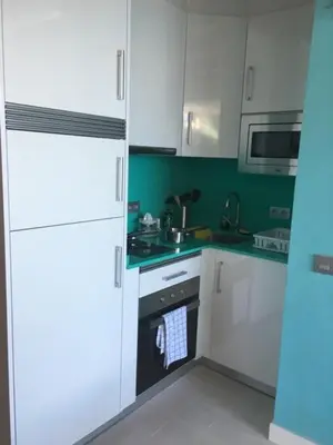 a kitchen with white cabinets and a black oven at Blue sea front by Hello Homes Sitges in Sitges