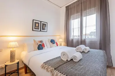 a bedroom with a large white bed with towels on it at Sweett - The Roca House in Barcelona