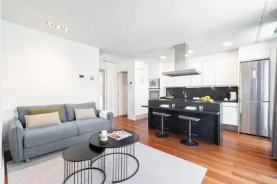a living room with a couch and a kitchen at Aspasios Paseo de Gracia Apartments in Barcelona