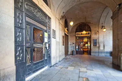 an empty alley way with a building with a store at My Address in Plaza Real in Barcelona