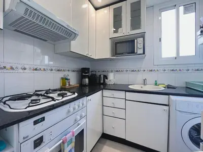 a white kitchen with a stove and a sink at Stay U-nique Apartments Lepant in Barcelona