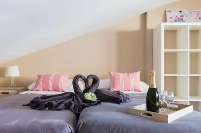 a bedroom with a bed with purple sheets and a bottle of wine at Matarolux15 in Mataró