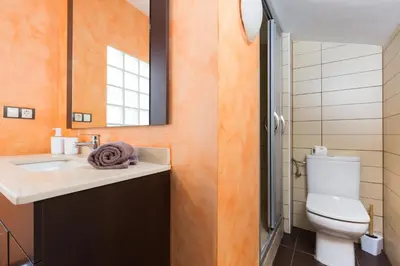 a bathroom with a toilet and a sink and a mirror at Matarolux15 in Mataró