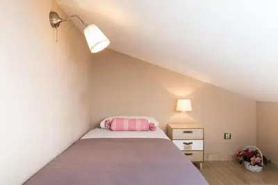 a small bedroom with a bed and a lamp at Matarolux15 in Mataró