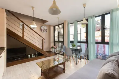 a living room with a staircase and a table at Matarolux15 in Mataró