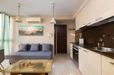 a living room with a couch and a kitchen at Matarolux15 in Mataró