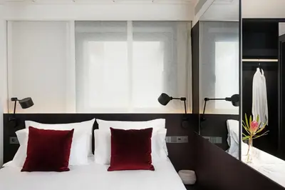 a bedroom with a white bed with red pillows at Yurbban Ramblas Boutique Hotel in Barcelona