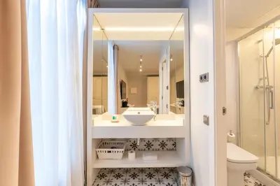 a bathroom with a sink and a toilet and a mirror at Serennia Fira Gran Via Exclusive Rooms in Hospitalet de Llobregat