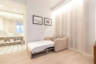 a bedroom with a bed and a bathroom with a mirror at Serennia Fira Gran Via Exclusive Rooms in Hospitalet de Llobregat