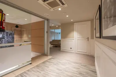 a hallway with a sliding glass door and a chair at Serennia Fira Gran Via Exclusive Rooms in Hospitalet de Llobregat