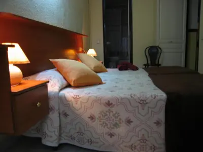 a bedroom with a bed with pillows and a wooden headboard at PENSIÓN Colmenero in Barcelona