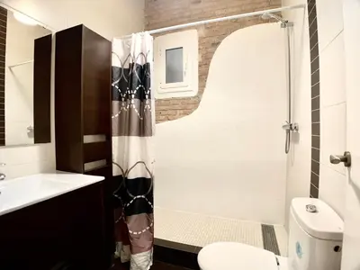 a bathroom with a shower and a toilet and a sink at Charm Miró in Barcelona