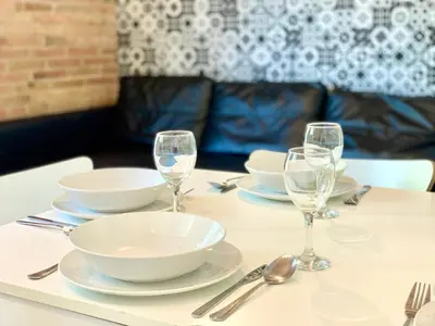 a table with plates and bowls and glasses on it at Charm Miró in Barcelona