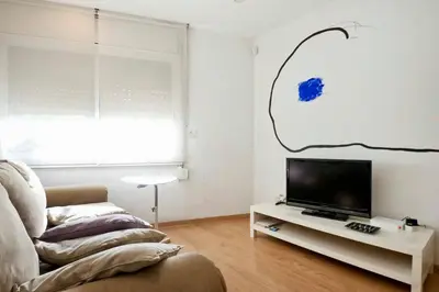 a living room with a couch and a tv on a table at Apartamento Noemi in Barcelona