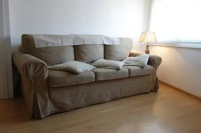 a brown couch in a room with a lamp at Apartamento Noemi in Barcelona