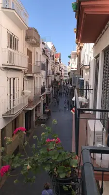 a city street with buildings and plants on a balcony at Casa Susana in Sitges