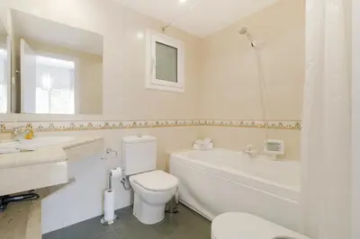 a bathroom with a toilet and a tub and a sink at Sweett - Monumental in Barcelona