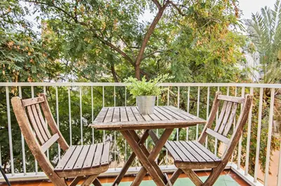 a wooden table and two chairs with a potted plant on a balcony at Sweett - Monumental in Barcelona