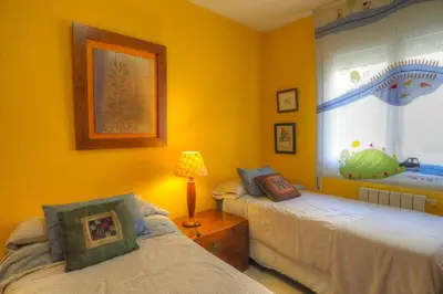 a yellow room with two beds and a window at Center Family Apartment by Hello Homes Sitges in Sitges
