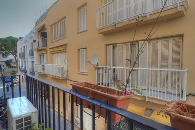 a balcony with two potted plants on a building at Center Family Apartment by Hello Homes Sitges in Sitges