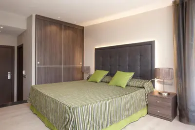 a bedroom with a large bed with green pillows at Dalia Ramblas in Barcelona