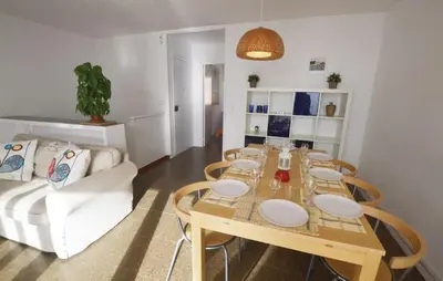 a living room with a table with chairs and a couch at Duplex en frente de la playa al lado de Barcelona in Canet de Mar