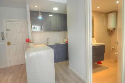 a kitchen with blue cabinets and a white counter top at Orquidea Apartment by Hello Homes Sitges in Sitges