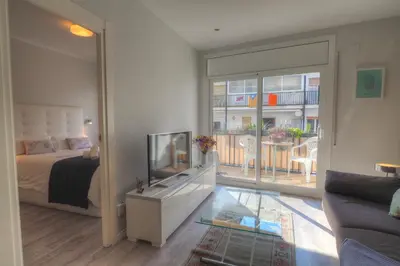 a bedroom with a bed and a television in a room at Orquidea Apartment by Hello Homes Sitges in Sitges