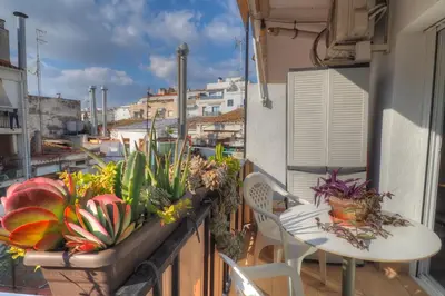 a balcony with a table and chairs and plants at Orquidea Apartment by Hello Homes Sitges in Sitges