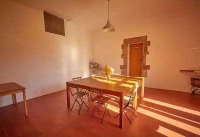 a dining room with a wooden table and chairs at Masia de Vallforners in Tagamanent