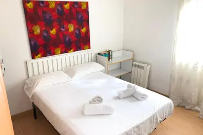 a white bed in a room with a painting on the wall at New! Apartment for 3 people near Fira Gran Via in Hospitalet de Llobregat