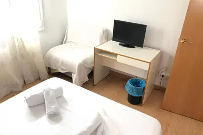a bedroom with a bed and a desk with a television at New! Apartment for 3 people near Fira Gran Via in Hospitalet de Llobregat