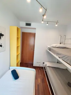 a bedroom with two bunk beds and a door at Barcelona-Forum Apartments in Barcelona