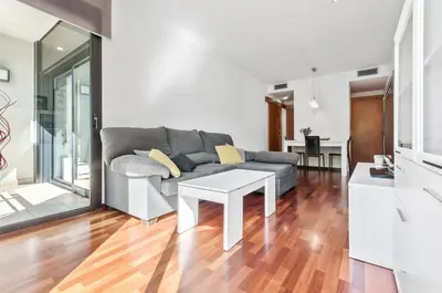 a living room with a couch and a table at Barcelona-Forum Apartments in Barcelona