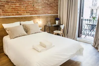 a bedroom with a white bed with towels on it at Cien in Barcelona