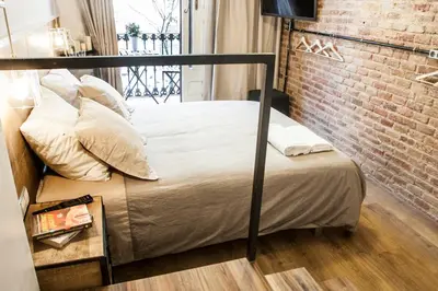 a bed in a room with a brick wall at Cien in Barcelona