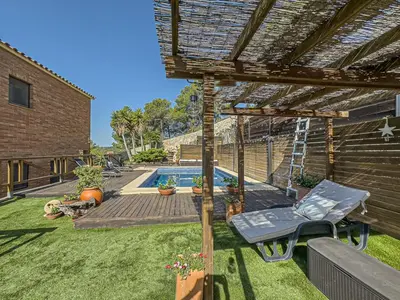 a backyard with a swimming pool and a pergola at Villa Mar & Natura Sitges in Canyelles