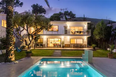 a house with a swimming pool in front of a house at Villa Bella Vista in Castelldefels